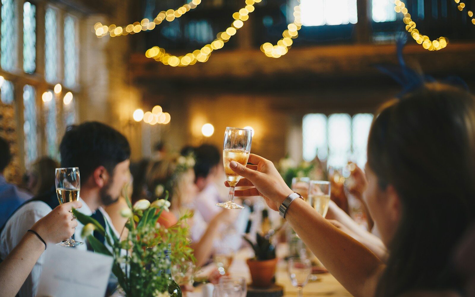 people raising wine glass in selective focus photography
